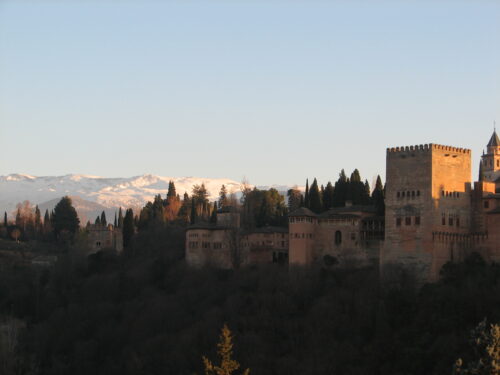 A photo of the Alhambra against the backdrop of snow-capped mountains