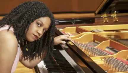 Dr. Rochelle Sennet sitting at a grand piano.