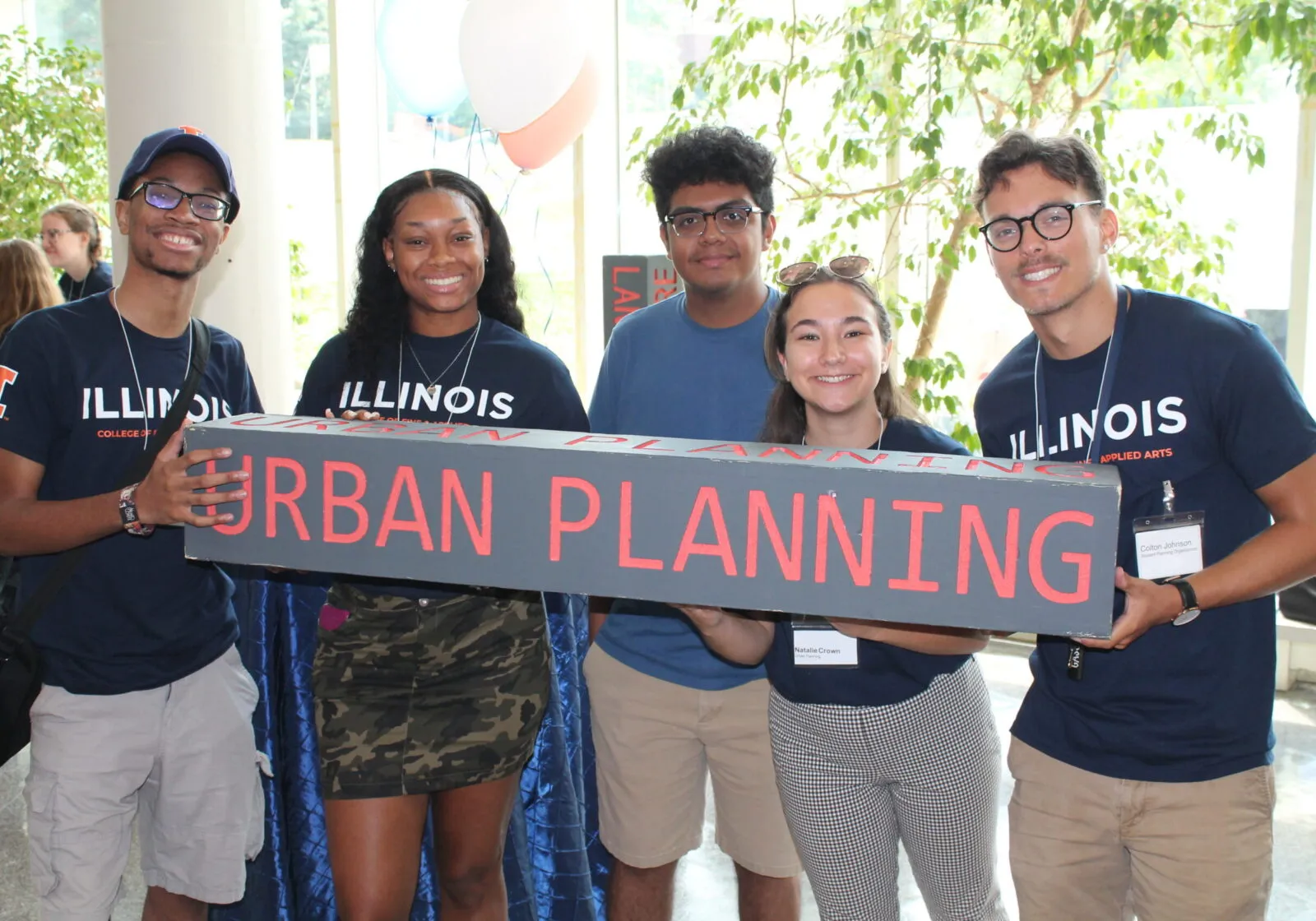 5 students at New Student Welcome hold up urban planning sign