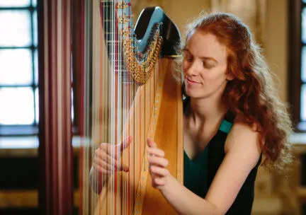 student playing the harp