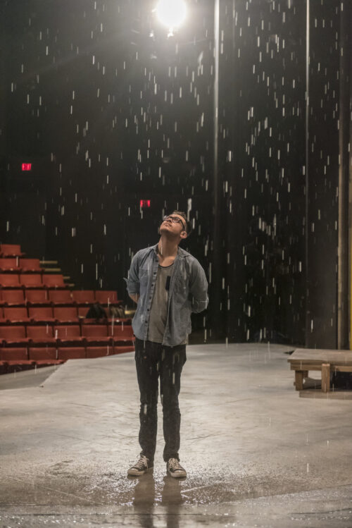 student standing on stage in rain