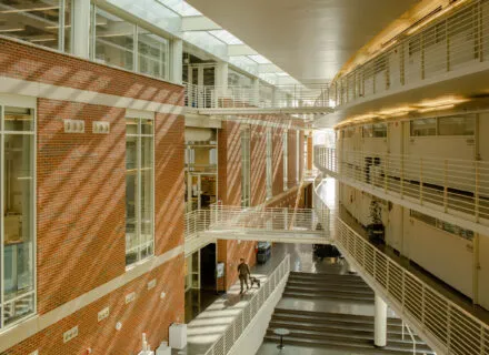 inside of building, red brick on one wall, open atrium three stories high