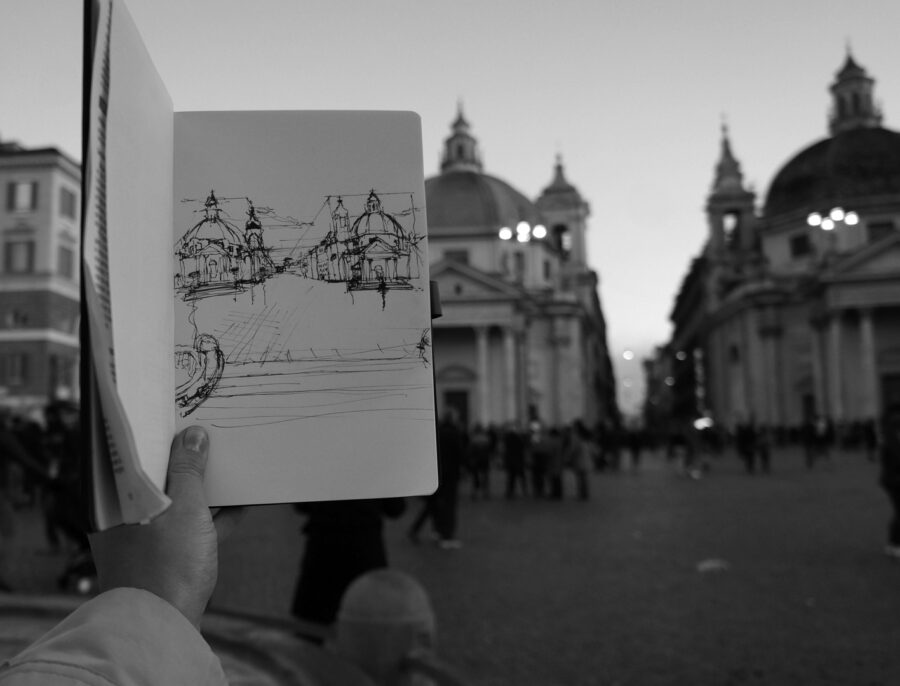 drawing of buildings held in front of the buildings