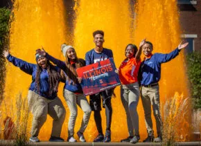 5 students in front of an orange fountain
