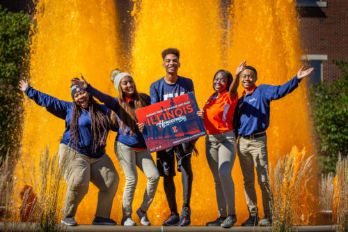 5 students in front of an orange fountain