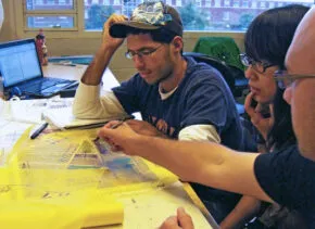 two students and an instructor with design materials