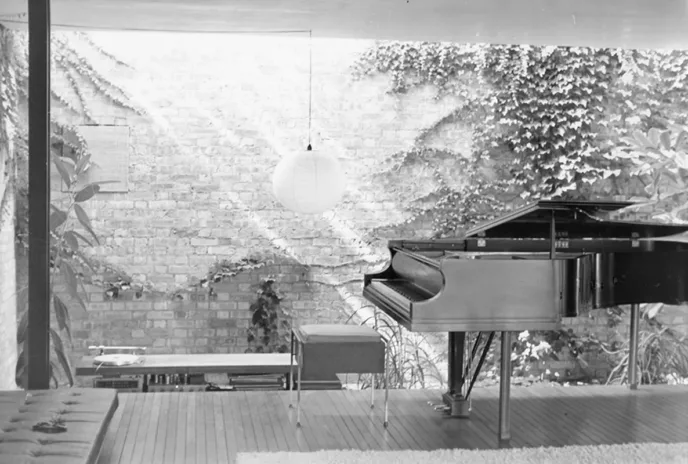 Black and white photo of interior of a house with a piano