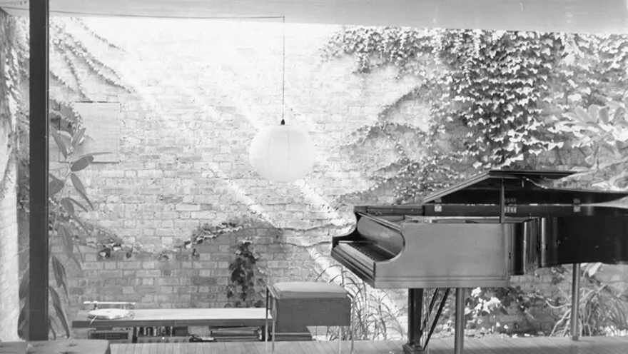 Black and white photo of interior of a house with a piano