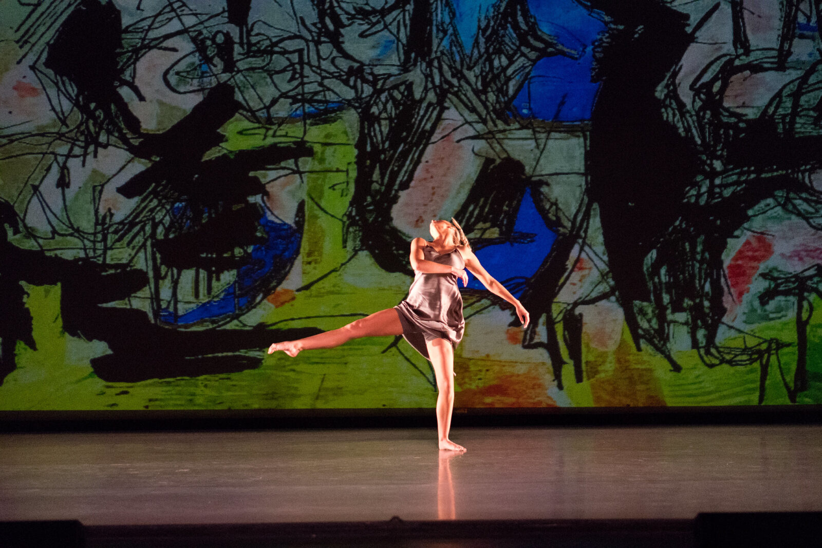 a person dances onstage with colorful graphic background