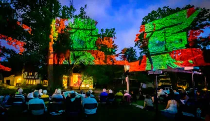 outside dusk with brightly colored projectsions on brick house