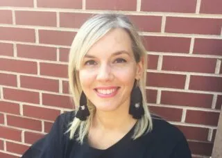 chiara wearing a black shirt and a brick wall behind