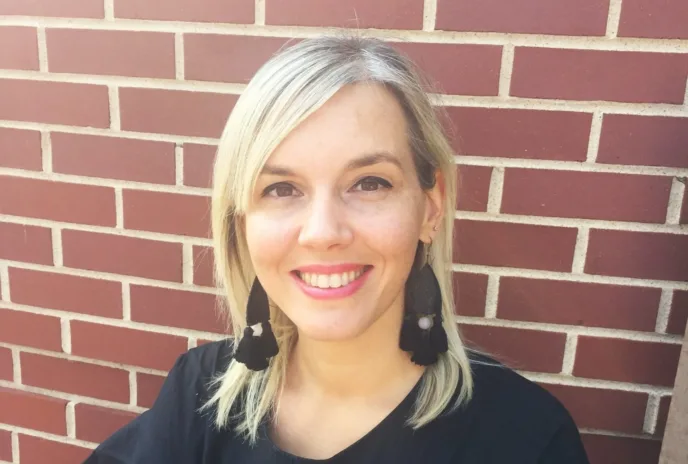chiara wearing a black shirt and a brick wall behind