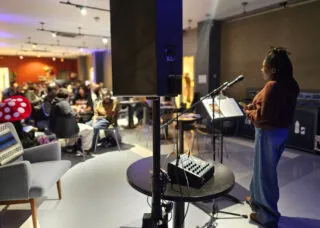 Person speaking on mic in front of an audience