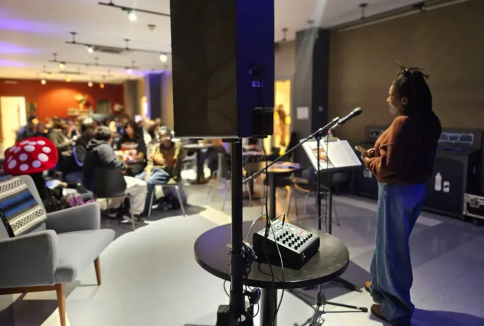 Person speaking on mic in front of an audience