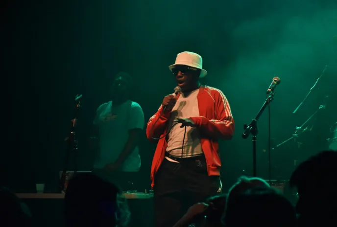 person singing into mic on a dark stage