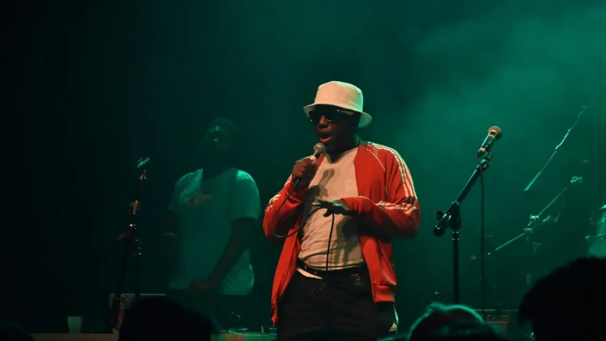 person singing into mic on a dark stage