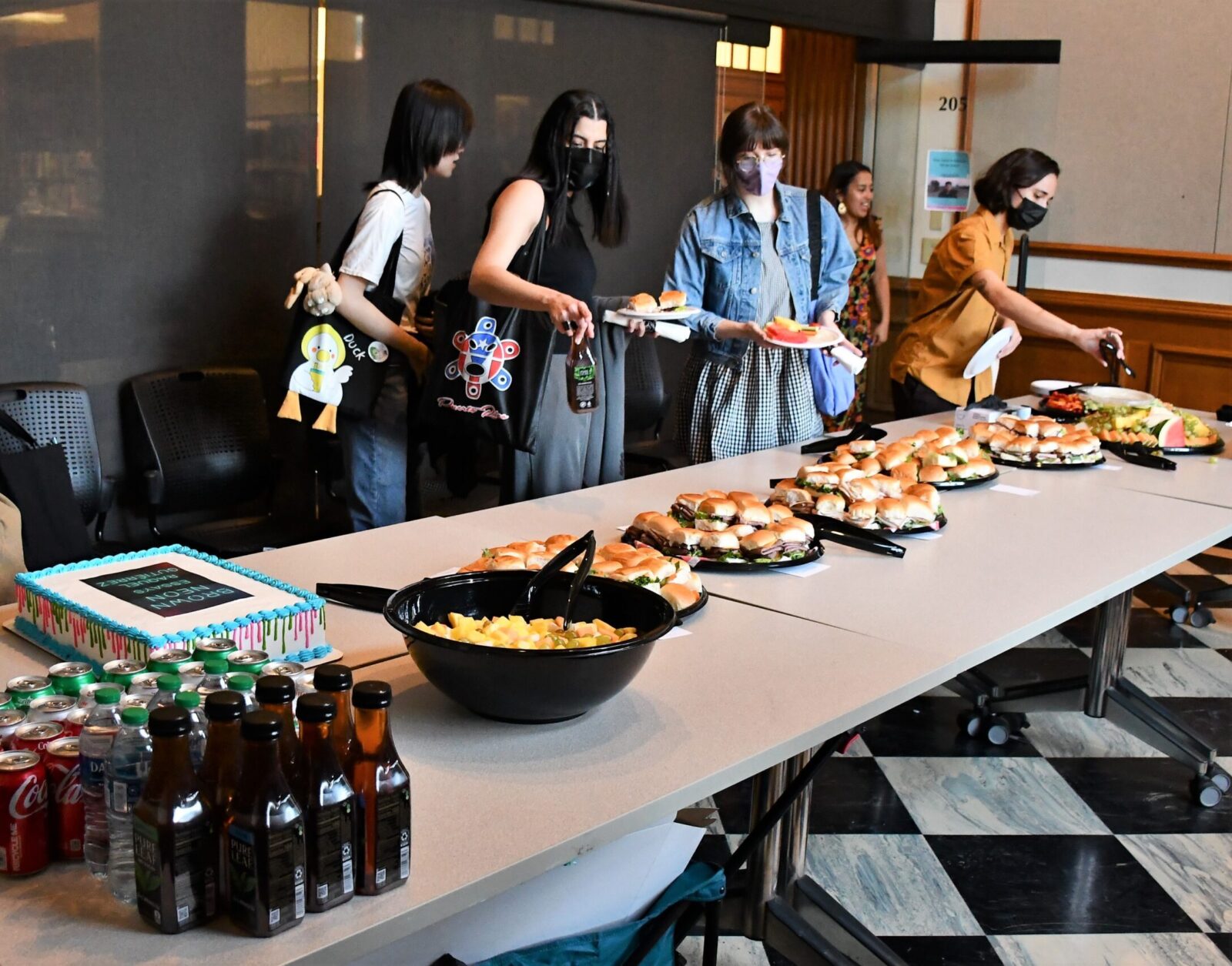 people walking along table getting buffet food