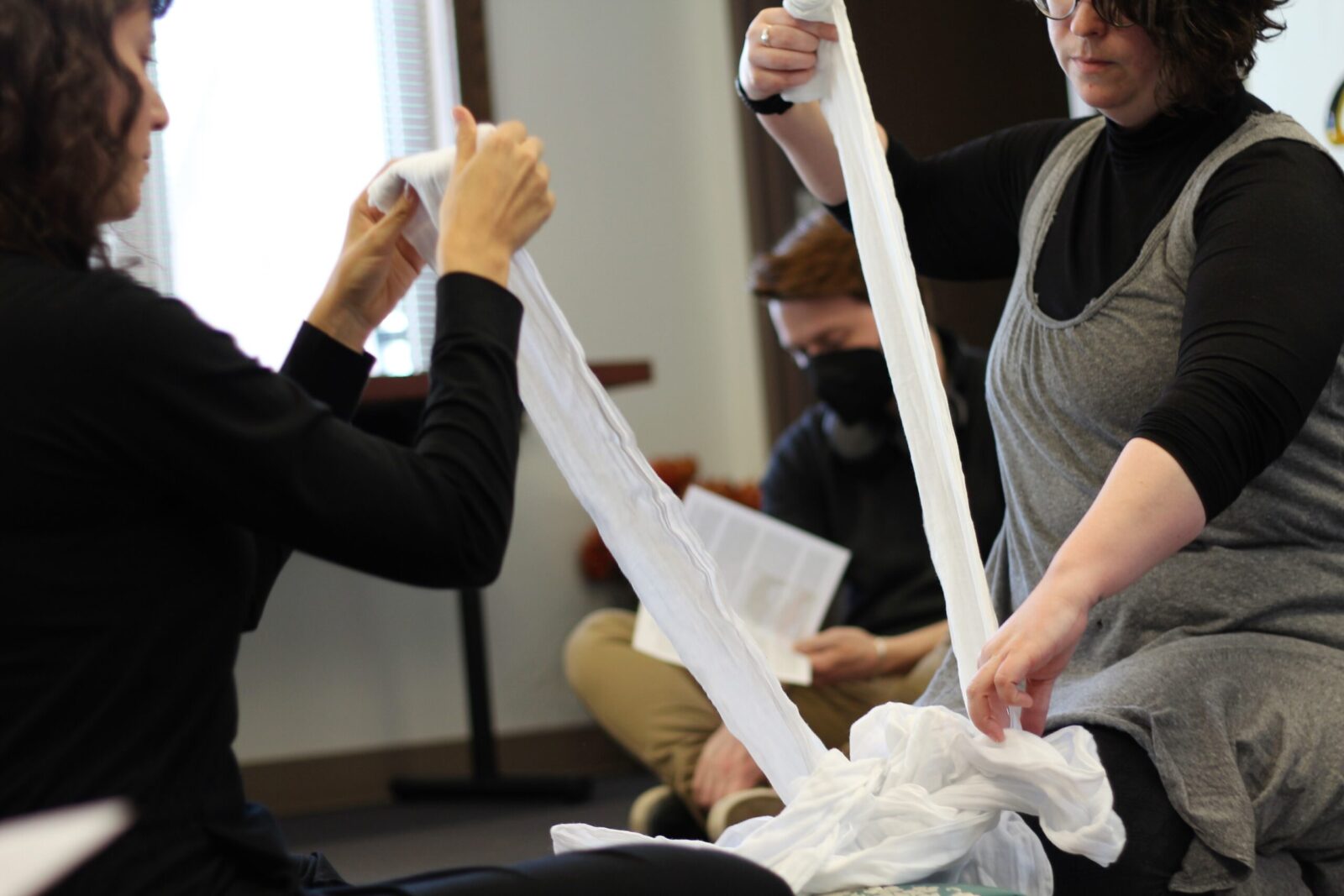 two people pulling pieces of fabric