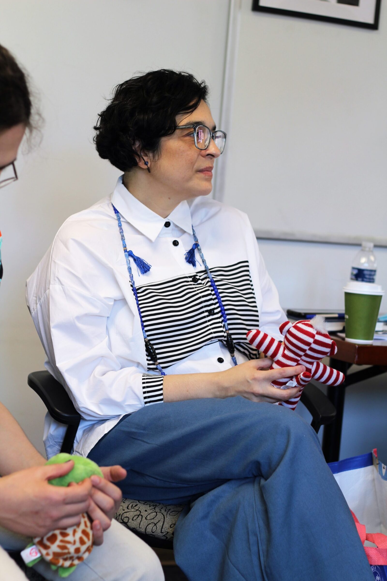 a person sitting holds a crafted doll