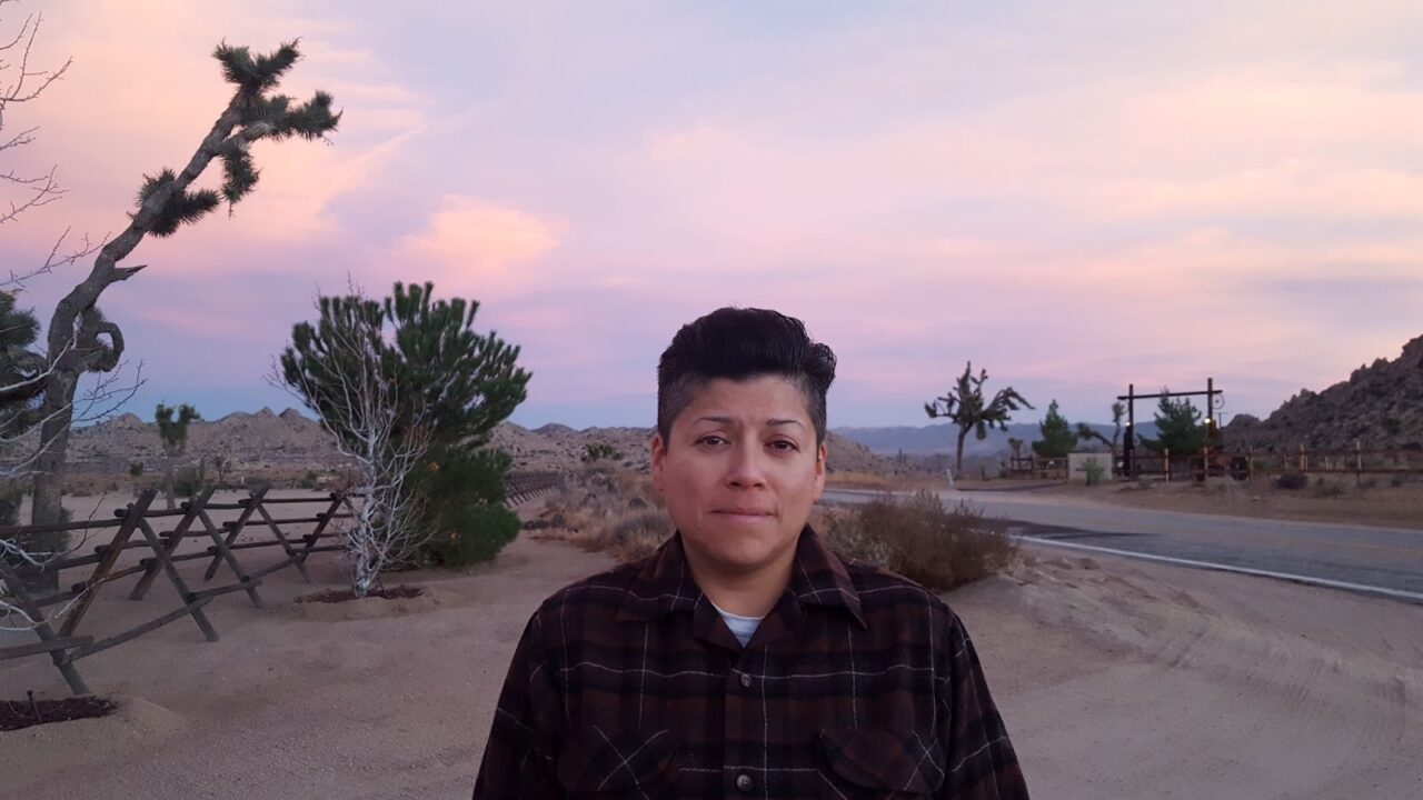 raquel centered with a desert landscape behind them