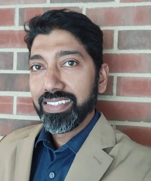 Photo of Prof. Arnab Chakraborty standing in front of a brick wall