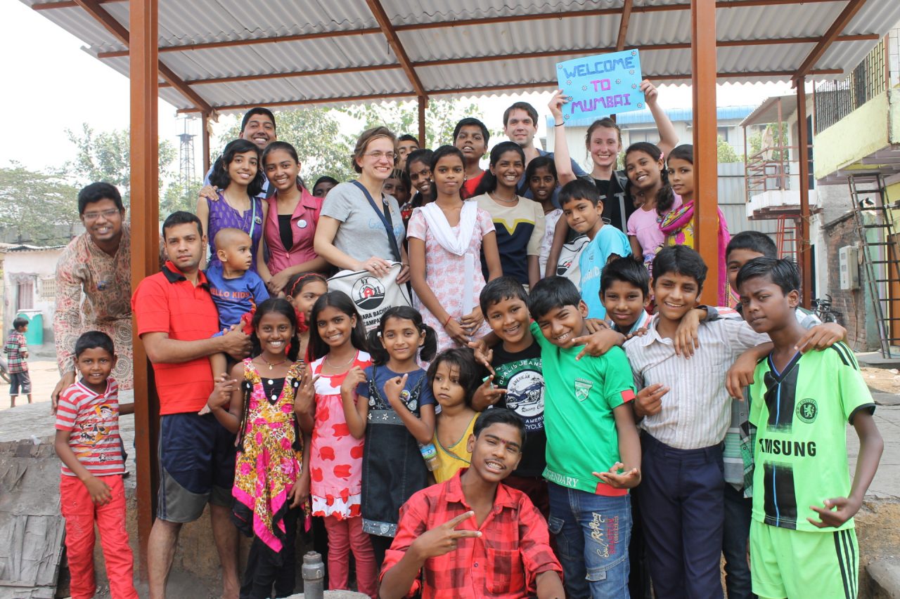 Students with large group of children in Mumbai, India