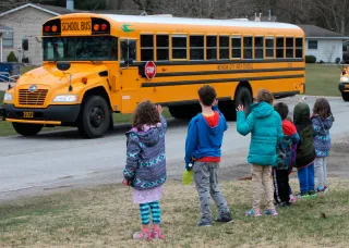 Photo of students waving to school bus