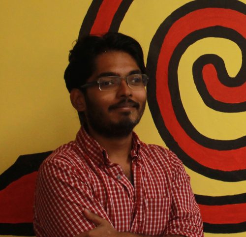 Efadul Huq in front of yellow wall with orange swirl