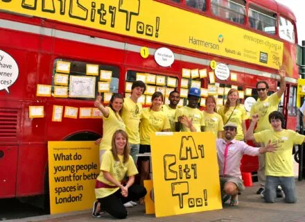 Young people in front of a red double-decker bus