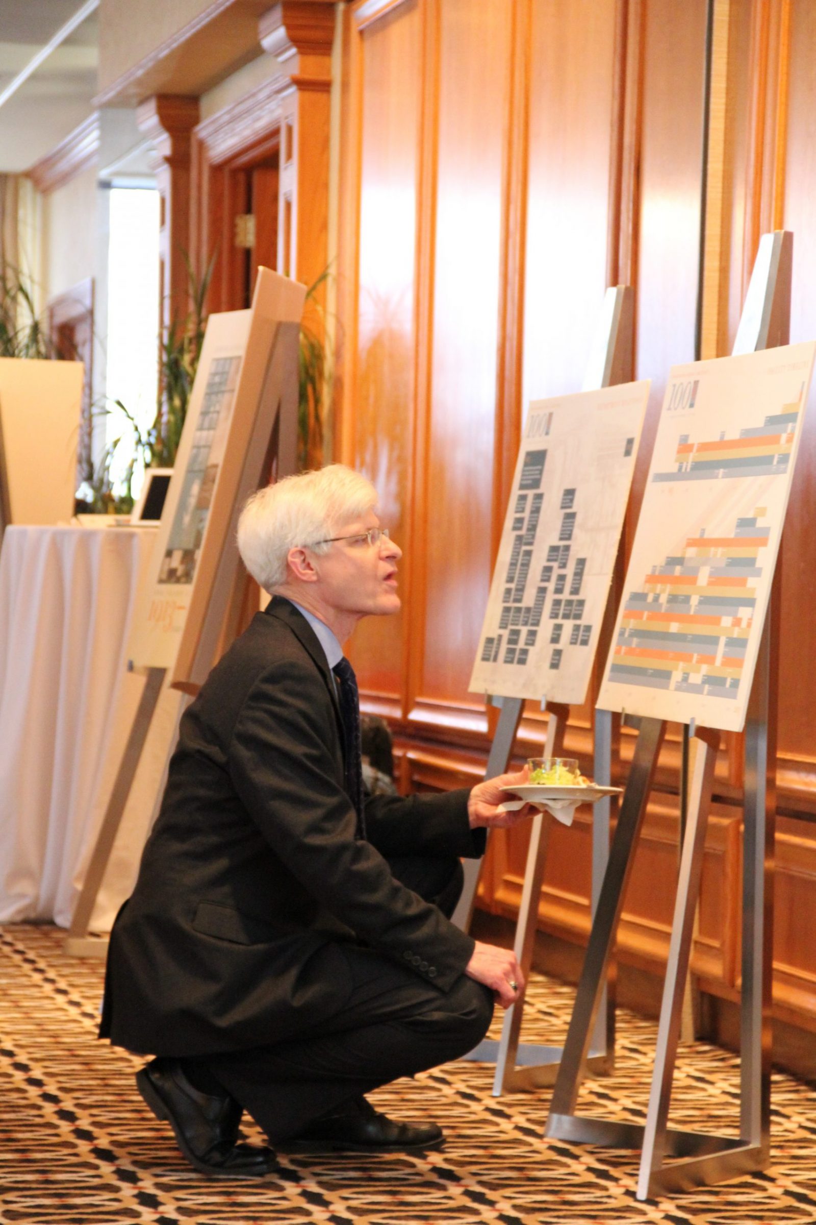 man looking at work on a panel board