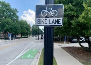 Photo of bike lane sign and actually bike lane along side of a rode on UIUC campus