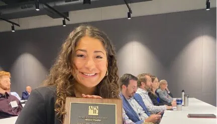 Photo of Roya holding APA-IL award in conference room