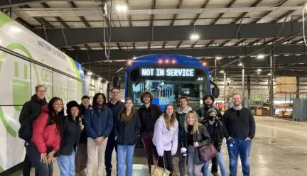 BAUSP seniors standing in a bus barn