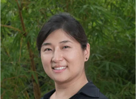 Photo of Colleen outside in front of a green tree