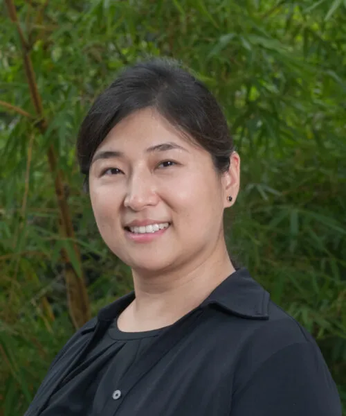 Photo of Colleen Chiu-Shee in front of green trees