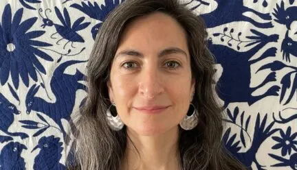 Photo of Daniela Morales Fredes in front of a blue and white floral quilt