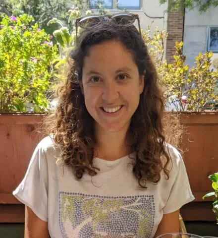 Photo of Colleen outside in front of a green tree