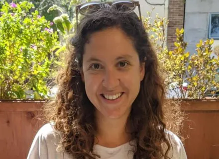 Photo of Colleen outside in front of a green tree