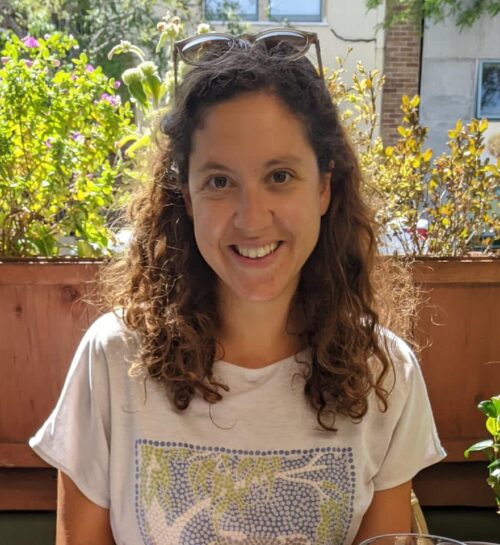 Photo of Colleen outside in front of a green tree