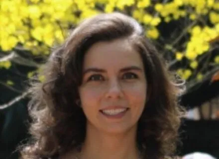 Photo of Julia Paiva outside in front of a green tree