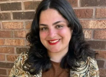 Photo of Luisa Ponte against a brick wall 