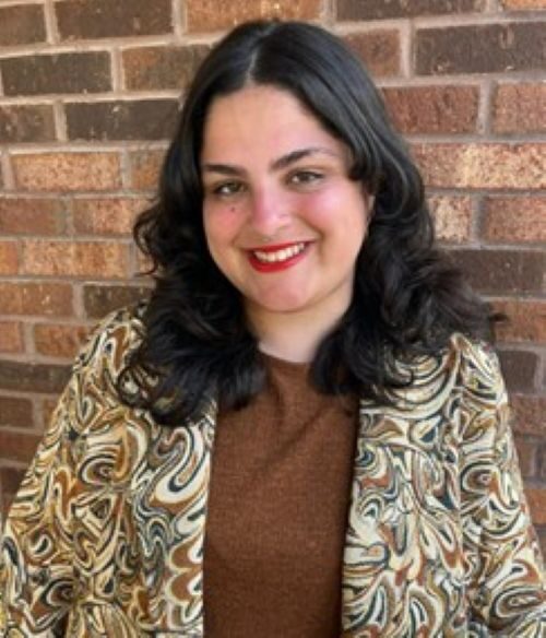 Photo of Luisa Ponte against a brick wall 