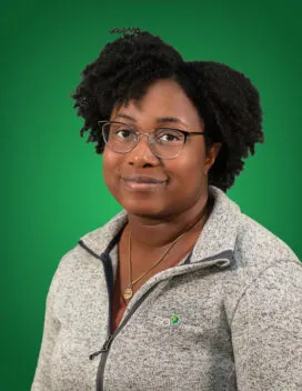 Photo of Tyler Huggins in front of a green background