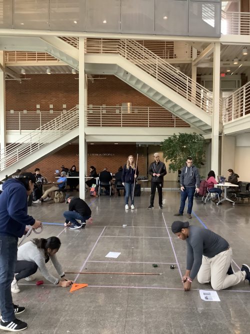 Ground view of students laying out a church plan in the TBH atrium 