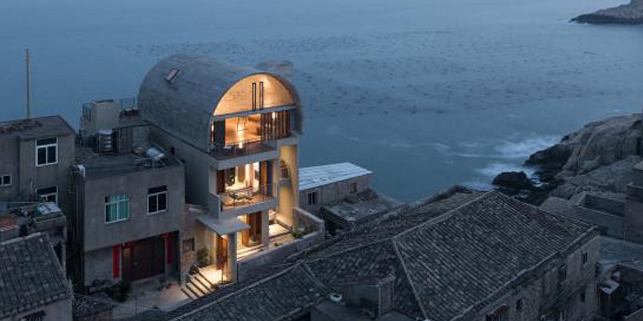 aerial view of house at dusk with water in background 