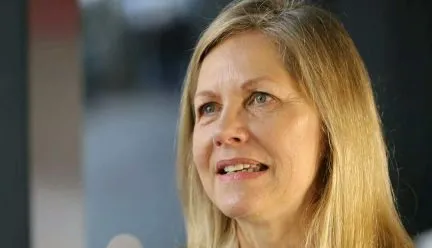 headshot of Martha Thorne with bookcase behind her 