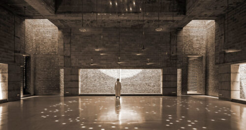 a person standing in front of a brilliantly lit wall with dancing lights