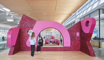 Pink architectural installation inside a campus building 