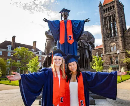 graduates posing in front of the alma mater