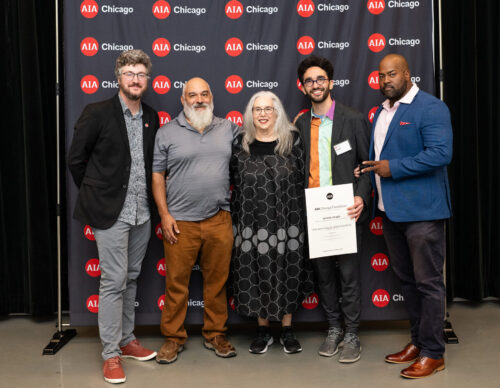 five people smiling in front of AIA Chicago step and repeat